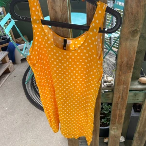 Gul prickig sommarklänning - Superfin gul klänning med vita prickar från H&M. Ärmlös modell med rund halsringning och lätt, luftig passform. Perfekt för varma dagar och ger en riktigt glad vibe!