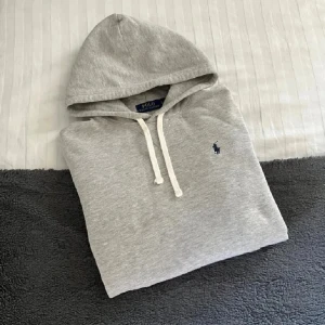 Ralph Lauren Grå Hoodie - Säljer denna riktigt feta Hoodie från Ralph Lauren i storlek L. Mycket fint skick, härlig och mjuk Hoodie som knappt är använd. Hör gärna av er vid funderingar🙌