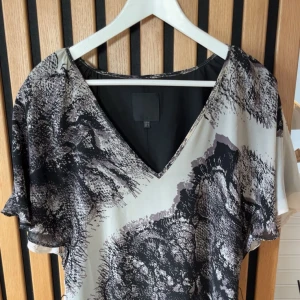 Svartvit mönstrad kortklänning - Klänning med coolt mönster som går att styla snyggt med ett skärp.