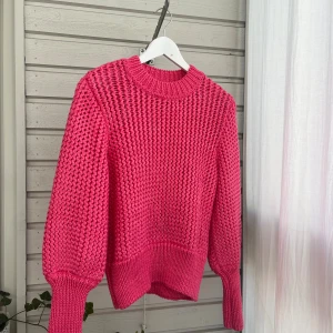 Rosa stickad tröja från H&M - Säljer en chunky stickad tröja från H&M i en härlig rosa färg. Tröjan har grovstickat mönster, rund hals och långa ärmar med breda muddar.