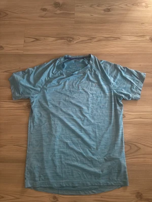 Blå randig t-shirt Energetics M - Säljer en blå t-shirt från Energetics i storlek M, perfekt för löpning och träning. T-shirten har korta ärmar, diskret randigt mönster och är tillverkad i lätt polyester med DryPlus-teknologi som håller dig torr. Snygg sportig look och skön passform.