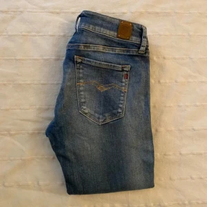Replay Anbass jeans blå denim - Snygga Replay Anbass jeans i klassisk blå denim med coola detaljer på bakfickorna och brunt läderpatch vid midjan. Jeansen har en rak passform och är tillverkade i slitstarkt jeansmaterial. Perfekta för dig som gillar stilrena och tidlösa jeans.perfkr för dig som är 158-165 skit snygga till hösten 