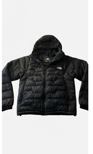 Svart pufferjacka från The North Face - Helt ny Svart pufferjacka från The North Face med huva och dragkedja. Jackan har quiltad design och är tillverkad i syntetmaterial, perfekt för kalla dagar. Klassisk logga på bröstet och snygg passform som funkar till streetwear.