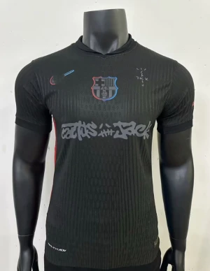 Svart FC Barcelona x Nike fotbollströja - Snygg svart FC Barcelona fotbollströja från Nike med klubbmärke på bröstet och unikt grafitti-tryck över magen. Tröjan har korta ärmar, rund hals och diskreta röda och blå detaljer. Perfekt för dig som vill sticka ut på planen eller läktaren.