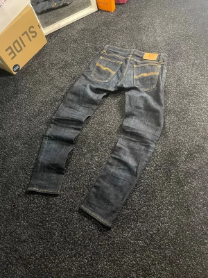 Mörkblå Nudie Jeans  W27 L32 - Säljer dessa snygga mörkblå nudie jeans. De sitter riktigt snyggt och passar någon med smalare midja. Kom privat vid frågor.