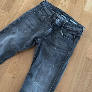 Replay anbass  - Märkgråa/svarta replay anbass jeans med slitningar. Storlek: 28/32 men passar 28/34. Bara att höra av sig vid frågor eller funderingar.