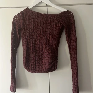Vinröd spetsblus från Pull&Bear - Säljer en vinröd långärmad blus från Pull&Bear i genombruten spets med blommigt mönster. Toppen har en tight passform och rundad halsringning. Perfekt för dig som gillar romantiska detaljer och vill sticka ut lite extra. Är lite shoulder off därför den är lite sne❤️