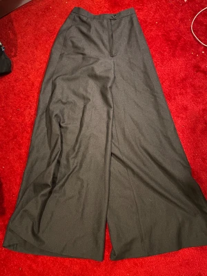 Svarta wide kostymbyxor, storlek 34 - väldigt vida / baggy svarta byxor i stl 34 med riktigt hög midja. midjan passar XS. knapp och dragkedja framtill. skitsnygga