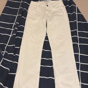 Vita jeans från Smog Denim 30/32 - Snygga vita slim  jeansbyxor från Smog Denim i klassisk femficksmodell. Byxorna har raka ben, normal och är tillverkade i mjukt jeanstyg. Perfekt för dig som gillar stilrena och ljusa looks. Storlek 29/32. Modellen är slim jeans