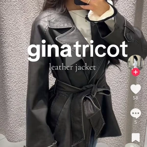  skinnjacka med bälte Gina Tricot - Snygg svart skinnjacka från Gina Tricot med markerade sömmar och bälte i midjan. Jackan har stora slag, långa ärmar med knapprade detaljer och en stilren, lite oversized passform. Perfekt för dig som vill ha en edgy och trendig look. DEN ÄR HELT NY har aldrig använt dä jag fick den i present och hann ej returnera.