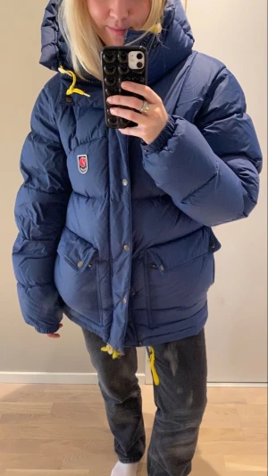 Blå pufferjacka från Fjällräven - Vill byta min fjällräven i storlek M. Byter mot svart i antingen S eller M.