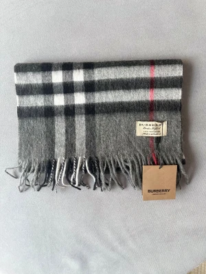 Grå Burberry Halsduk - Hej! Säljer nu min gråa burberry halsduk. Den är sjukt snygg och är perfekt till vintern! Ett måste helt enkelt. Hör av dig om du undrar något! 