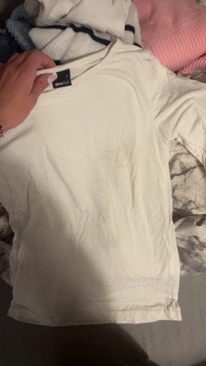 Vit långärmad tröja från Gina Tricot - En enkel och stilren vit långärmad tröja från Gina Tricot i storlek S. Tröjan har rund hals och är gjord i mjuk bomull, perfekt för att bygga lager eller bära som den är. Passar dig som gillar clean och basic stil.