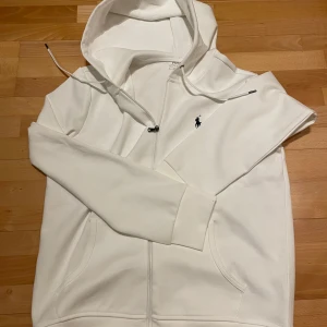 Ralph Lauren Zip Hoodie - Hej, säljer nu denna vita zip hoodien från Ralph Lauren. Riktigt bra skick, tvättad skonsamt så tyg och färg är i princip nyskick. Storlek M. Hör gärna av er vid frågor!😃