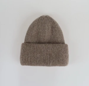 Satinfodrad mössa beige - Denna riktigt snygga stickade mössa ger en lyxig och exklusiv känsla samtidigt som den håller en stilren och tidlös design. På insidan finns det ett insytt lager av satin som både skyddar håret och ger extra komfort. Denna kombination av stil och funktionalitet gör den till ett självklart val för dig som söker en mössa av elegans. Mössan är unisex och onesize.😁