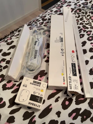 IKEA MITTLED LED ljuslist + STYRBAR fjärrkontroll - Smart LED ljuslist MITTLED från IKEA med Zigbee-stöd, inklusive STYRBAR fjärrkontroll och TRÅDFRI komponenter. Komplett paket för smart belysning, allt i mycket gott skick med originalförpackningar och tillbehör. Perfekt för kök eller arbetsyta.