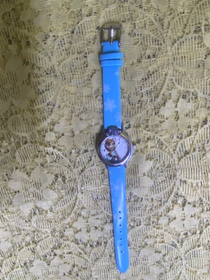 Frozen klocka med snöflingor - Säljer en cool Frozen klocka med motiv av Elsa på urtavlan och snöflingor på armbandet. Finns i blått, vitt, rosa och lila med silvrigt runt boetten och en liten krona upptill. Armbandet är i syntetmaterial och har klassiskt spänne. Nya batteri, nya klocka. 135kr/st 