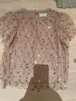 Rosa paljettblus  -  rosa glittriga paljetter från Lindex med volangärmar. 