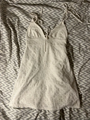 Vit/creme sommarklänning från Divided H&M - Söt krämvit kortklänning från Divided H&M med broderade detaljer och tunna axelband som knyts i storlek S. Kika gärna in mina andra annonser och skriv vid frågor!🥰