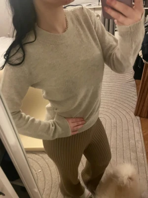 Beige stickad tröja i mjuk ullmix - Snygg beige stickad tröja med rund halsringning och långa ärmar. Tröjan har en klassisk passform och ribbstickade muddar vid ärmslut och nederkant. Perfekt för lager-på-lager och passar till allt. Materialet känns mjukt och skönt mot huden. Använd gärna köp nu