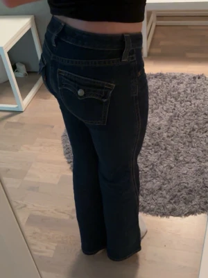 Low waist bootcut mörkblå Levi’s jeans - Mörkblå lågmidjade äkta Levis 527 jeans med bootcut passform och snygga fickdetaljer bak med knapp, knappt använda 💗