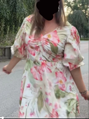 Slutsåld blommig klänning från HM - Slutsåld klänning från HM med blommigt mönster i rosa, grönt och vitt. Klänningen har puffärmar, v-ringning och snygg öppen rygg med knyt i ryggen. Perfekt för sommarens alla tillfällen. Storlek XS, ny med prislapp kvar💗