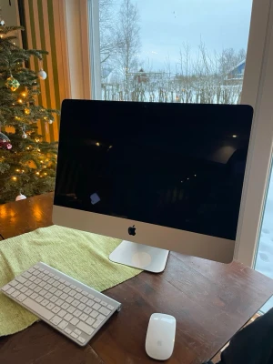 Apple iMac 21,5” - Snygg Apple iMac 21,5" med trådlöst tangentbord och Magic Mouse. Skärmen är stor och tydlig, perfekt för arbete eller underhållning. Datorn ser ut att vara i gott skick utan synliga repor eller skador. Allt fungerar som det ska och macOS är installerat. Den är från 2013 och nästan aldrig andvänd😄