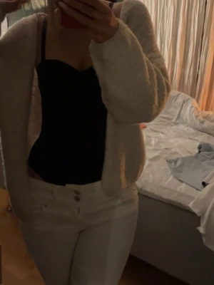 Vita bootcut jeans från Bershka - Säljer ett par vita jeans från Bershka med bootcut-ben. Byxorna har två knappar och dragkedja framtill, klassiska fem fickor och är gjorda i ett mjukt bomullsmaterial. Perfekta för dig som vill ha en clean och fräsch look. Är i storlek 36.