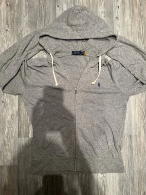 Ralph lauren zip hoodie - Säljer nu en riktigt fet grå Ralph zip up. Den är i lite tunnare material vilket gör den perfekt till sommaren och våren. Storleken är XS och vid förfrågan kan jag skicka bilder när jag (172,5) har på mig den🙌 tveka inte att skriva vid någon som helst fundering🤙