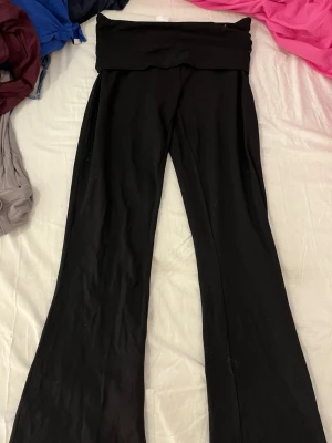 Svarta yoga pants från & Other Stories - Svarta yoga pants från & Other Stories i storlek S (36-38). De har låg midja och utsvängda ben vilket ger en snygg siluett. Mjukt och stretchigt material som sitter bekvämt hela dagen. Perfekta att styla med en oversized hoodie eller crop top. Endast testad🥰