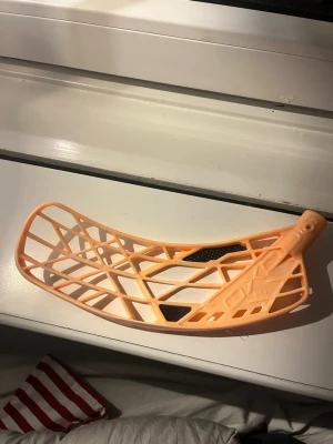 Innebandyblad Oxdog FSL orange - Säljer ett orange innebandyblad från Oxdog, modell FSL. Bladet är tillverkat i plast med öppet rutmönster och svarta förstärkningar. Perfekt för dig som vill byta blad på din klubba och få bättre bollkontroll.