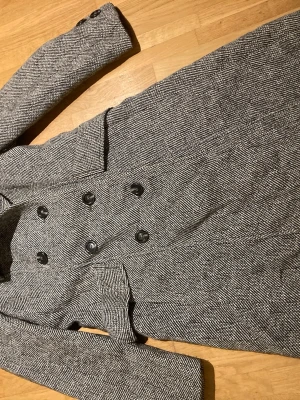 Vintage kappa  - Troligen 70-tal. Dubbelknäppt med slits bak. Blankt fodertrolig strl 34/36