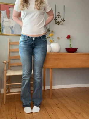 Blå bootcut jeans från Nelly - Superfina ljusblå bootcut jeans från Nelly!  Lite slitage (bild 4) men ingenting man lägger märke till!  nypris - 699 midjemått rakt över - 36cm med stretch  innerbenslängd - 83 cm                                       Pris går att diskutera vid snabb affär!