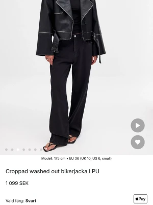 Croppad svart skinnjacka - Säljer en croppad svart bikerjacka i PU med breda slag, markerade sömmar och bälte i midjan. Jackan har en loose passform och vida ärmar för en edgy look. Perfekt för dig som vill sticka ut och addera lite attityd till outfiten.