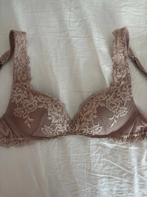 rosa intimissimi bh - Säljer en rosa bh med vackra spetsdetaljer och blommigt mönster. Bh:n har justerbara axelband och hakknäppning bak. 