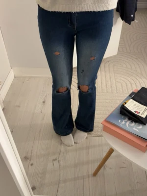 Blå bootcut jeans med slitningar. - Hej! Jag har valt att sälja mina blåa bootcut jeans, de är använda ett par gånger med har inte slitit sig alls mycket någonstans, hör av er vid intresse, priser eller om ni har någon annan fundering!😃