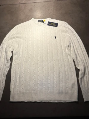 Ralph Lauren Kabelstickad Tröja - Säljer en sjukt snygg, skön, trendig Kabelstickad Tröja från Ralph Lauren som är helt ny. Storlek: L. Skriv vid frågor eller kom med bud!