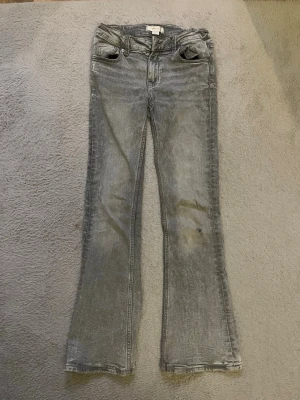 Grå bootcut jeans med slitningar - TRYCK INTE KÖP NU, hör av dig först!! Säljer ett par justerbara gråa jeans med bootcut passform ifrån Gina tricot young i storlek 146❤️ inga särskilda fickor, du får betala frakten! nypris: 359kr 