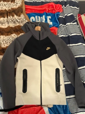 Nike hoodie i grått, svart och vitt - Hej,  nu säljer jag min Nike tröja på grund av att den passa inte mig längre eftersom jag har tränat nu ett tag. Den är helt ny o  fräsh. Skicket är bra o den är knappt använt. Storlek xs 