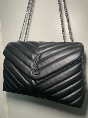 Svart quiltad axelväska - Säljer en svart quiltad axelväska. Kedjeremmar i metall.