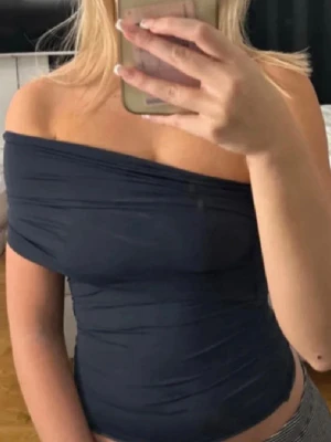 Mörkblå offshoulder topp Zara - Trendig mörkblå offshoulder topp från Zara med one shoulder. Toppen är asymmetrisk. Använd endast en gång. Storlek S.