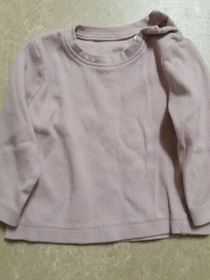 Tröja - En enkel och stilren ljuslila långärmad tröja i ribbad bomull. Tröjan har rund halsringning och mjukt material som känns skönt mot huden. Perfekt för lager på lager och passar till det mesta i garderoben.