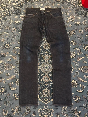 Selvedge Jeans Straight Fit - The Tailoring Club Selvedge jeans i nästintill nyskick. Jeansen är extremt fina och kommer få sjukt najs fade efter rätt mängd användningar. Mått: Midja:44cm Längd:111cm Innerben:87cm Benöppning: 18cm 