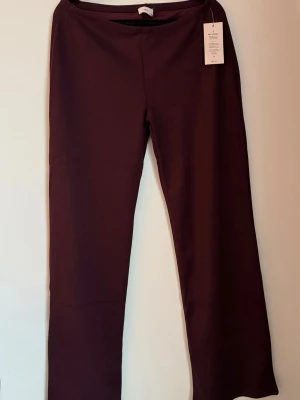 Vinröda byxor från Nelly - Säljer ett par vinröda loungebyxor från Nelly. Byxorna har en enkel och clean design med rak passform och elastisk midja. Perfekta för chill dagar eller när du vill vara bekväm men ändå se snygg ut. Säljer matchande långärmad tröja i samma färg- se mina annonser. Köptes vinter 2025. Helt nya med prislapp och orginalemballage.