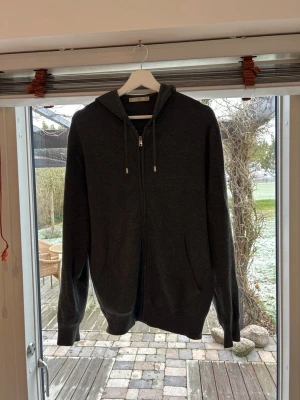 Stickad hoodie från Mango - Säljer en knappt använd grå stickad tröja av merino ull från Mango. Då den knappt är använd är den i nyskick och nopprar inte. Fundera inte över att höra av dig vid frågor.