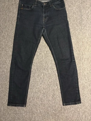 Tiger of sweden jeans!! - Säljer ett par mörkblå tiger of sweden jeans med skinny passform. Klassisk femficksmodell med knapp och dragkedja fram. Jeansen är tillverkade i mjukt denimtyg och har en stilren look som passar till det mesta.