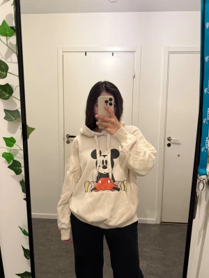 Beige hoodie med Mickey Mouse-tryck - Säljer en oversized beige hoodie från Disney med stort tryck av Mickey Mouse på framsidan. Tröjan har huva med snörning och en stor magficka. Storlek Xs men skulle säga S eller M. 