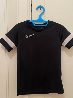 Svart träningströja - Svart träningströja från Nike. Passar 11-12Y.