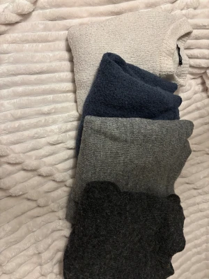 Stickade tröjor  - 4 st stickade tröjor ifrån lager i fyra olika färger, i väldigt bra skick den vita är den ända som kommit till användning medans dom andra bara legat och tagit plats. Kan köpas o styck men billigare för alla. 250 för alla 70 för 1 