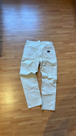 Vita cargopants från H&M, storlek 32 - Säljer ett par fräscha vita cargopants från H&M i storlek 32 32. Regular fit och stängs med dragkedja och knapp. Materialet är bomull och passformen är loose för en chill look.